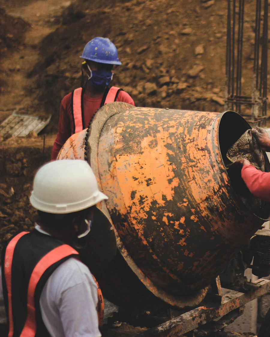 A crew in hard hats and high-visibility gear working on a large rusted cylinder at a dig site.