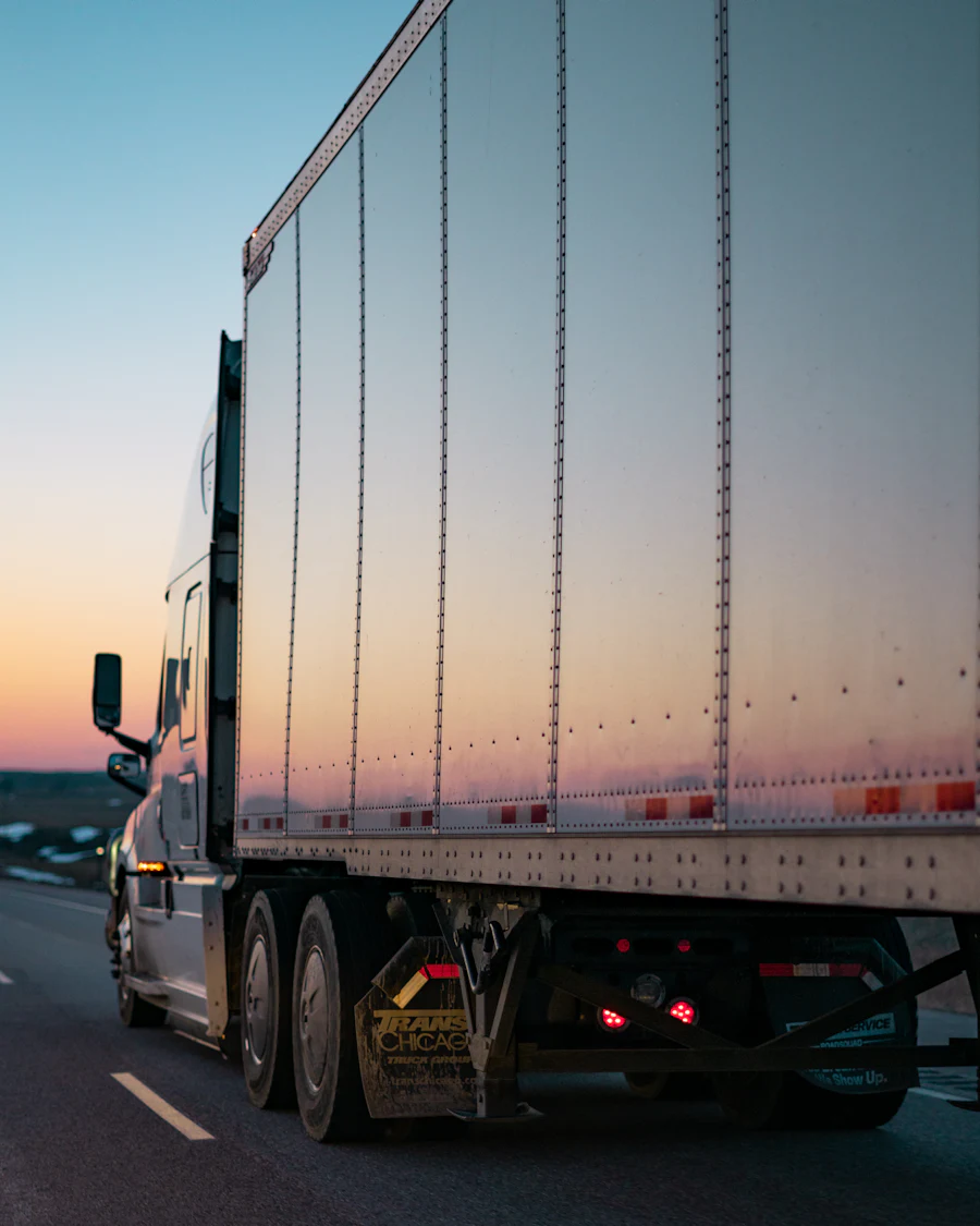 A tractor-trailer on the highway at dusk.