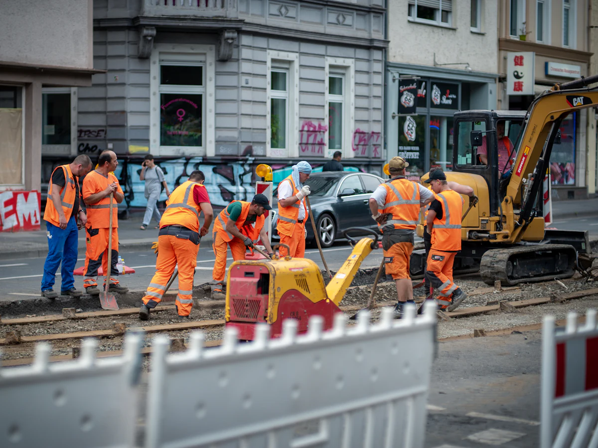 A road crew working a street excavation behind barriers.